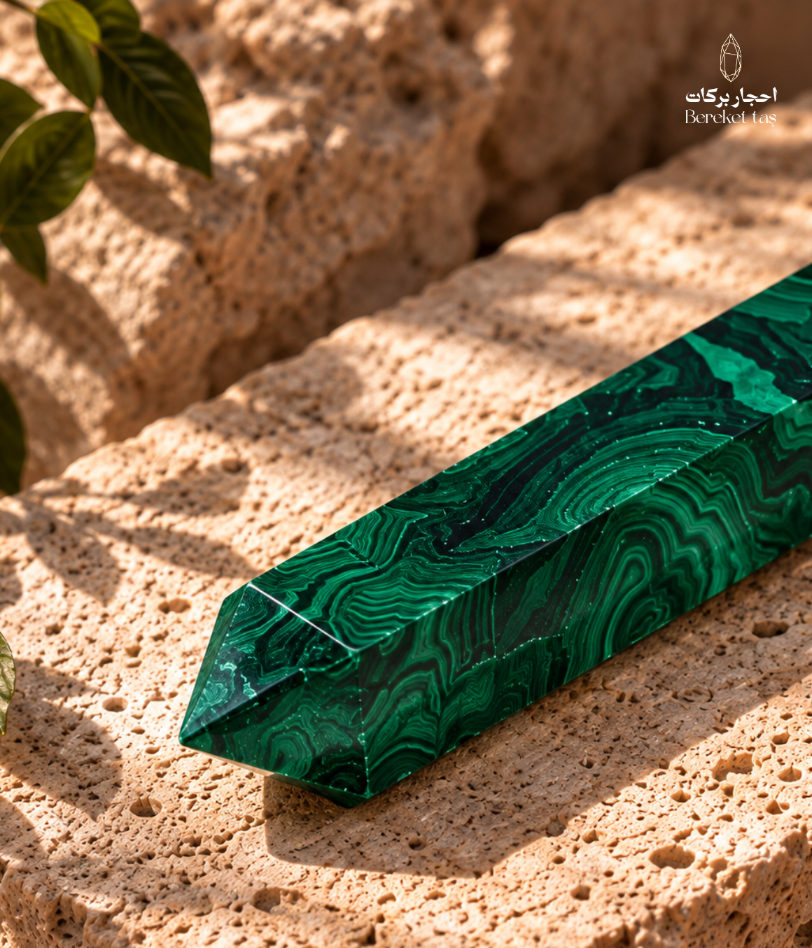 Natural Australian malachite with flowing green bands shown from a side angle on a travertine surface