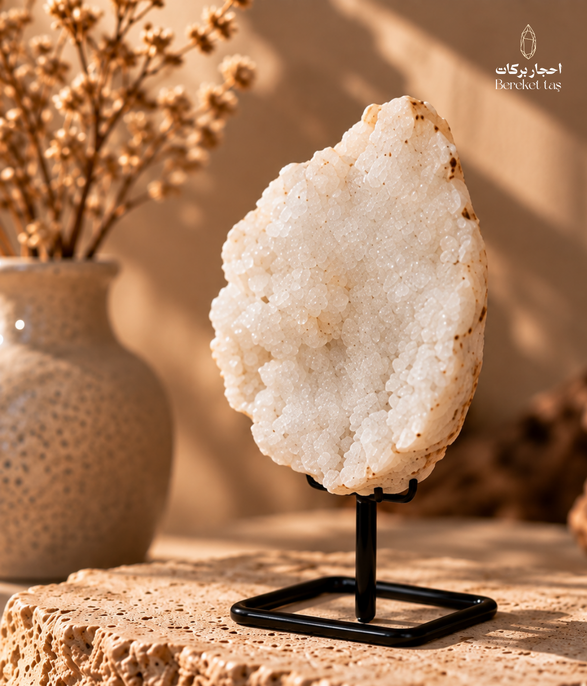 Natural Brazilian white quartz specimen with small crystal formations displayed on a black metal stand