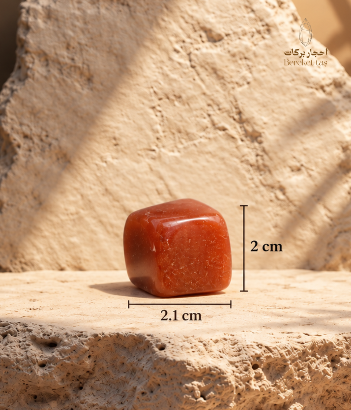 Natural polished red Carnelian stone showing 2.1 cm length and 2 cm width on a warm beige stone surface