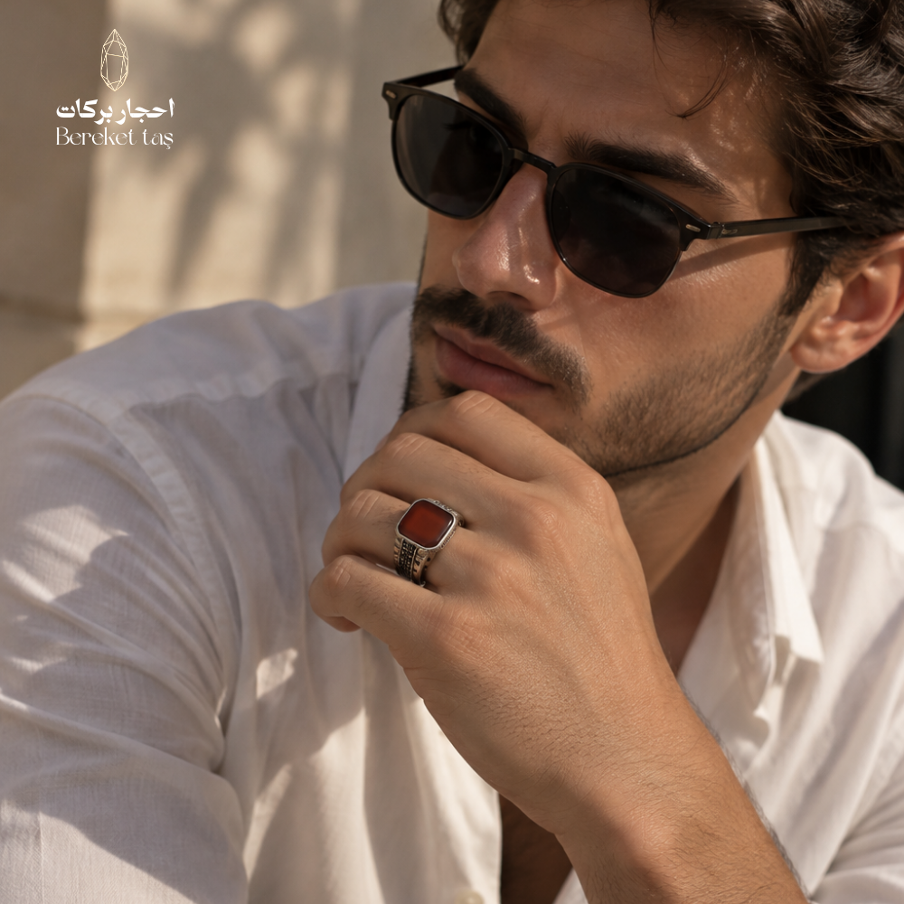 Man wearing a natural Red Agate ring in 925 Sterling Silver, styled with a white shirt and sunglasses, showcasing the gemstone and detailed silver setting.