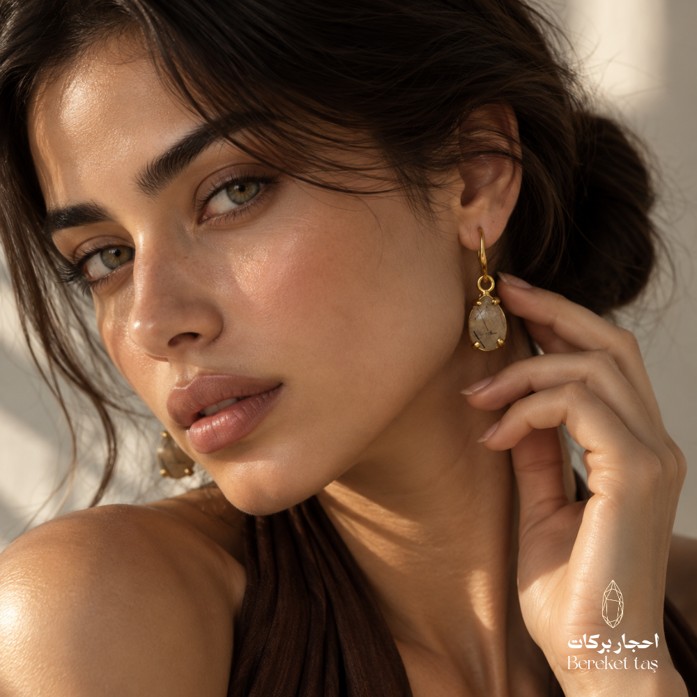 Elegant model wearing natural Rutilated Quartz drop earrings with gold-plated metal