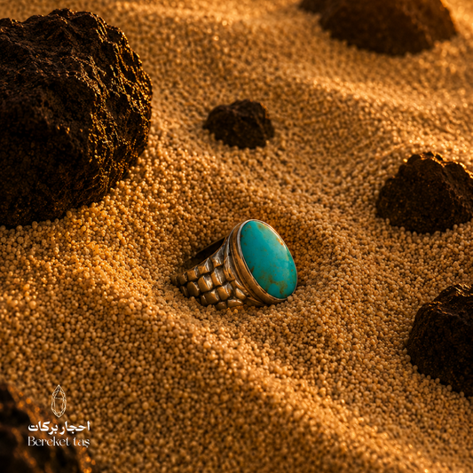 Iranian Nishapur turquoise ring set in 925 sterling silver, photographed on warm sand.