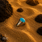 Elegant Iranian turquoise sterling silver ring displayed on warm textured sand, highlighting its vivid blue natural stone and polished silver setting.