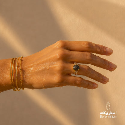 Natural Labradorite Peacock Stone ring worn on a hand with gold bracelets