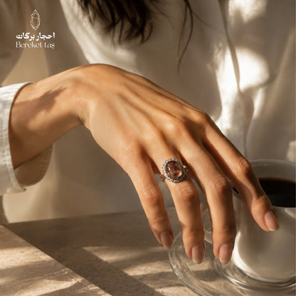 Natural Super Seven ring from Madagascar with brown and honey-toned shades, worn on hand beside a coffee cup