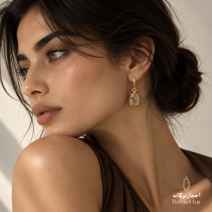 Natural Rutilated Quartz drop earring with gold-plated metal shown in an elegant side profile
