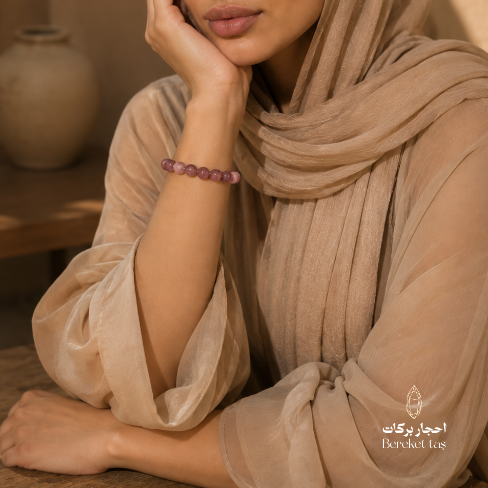 Pinkish purple ruby stone bracelet worn on the wrist with a beige outfit