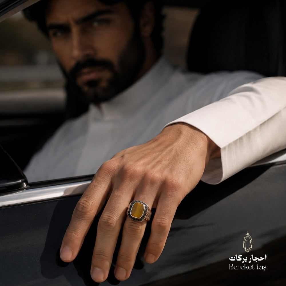 Men’s Tiger Eye ring in 925 sterling silver worn on the hand beside a car.