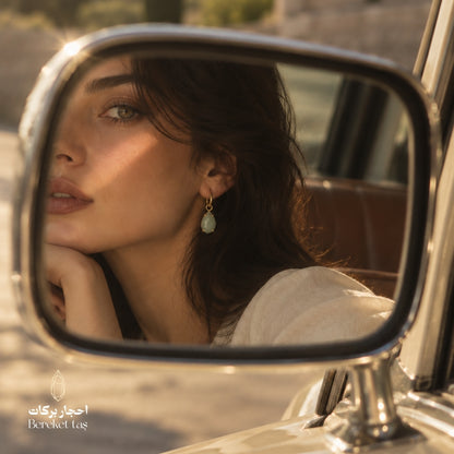 Natural Aquamarine earring with gold-plated metal reflected in a car side mirror