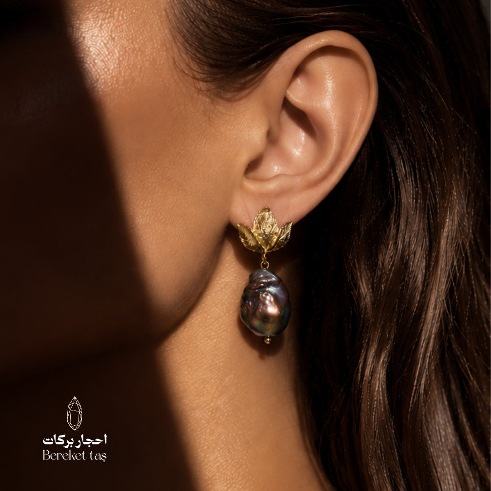 Close-up of a natural Baroque Pearl earring with gold-plated copper leaf detail worn in an elegant look
