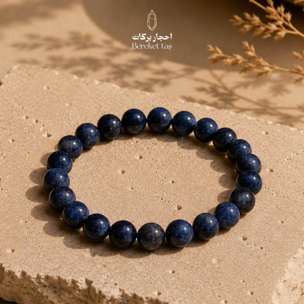 Blue Sapphire bracelet with 6 mm beads displayed on a natural stone surface