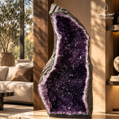 Natural Brazilian Amethyst geode with deep purple crystal formations displayed in an elegant interior setting
