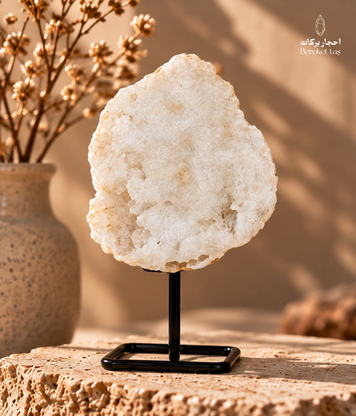 Natural Brazilian white quartz with small crystal formations displayed on a black metal stand