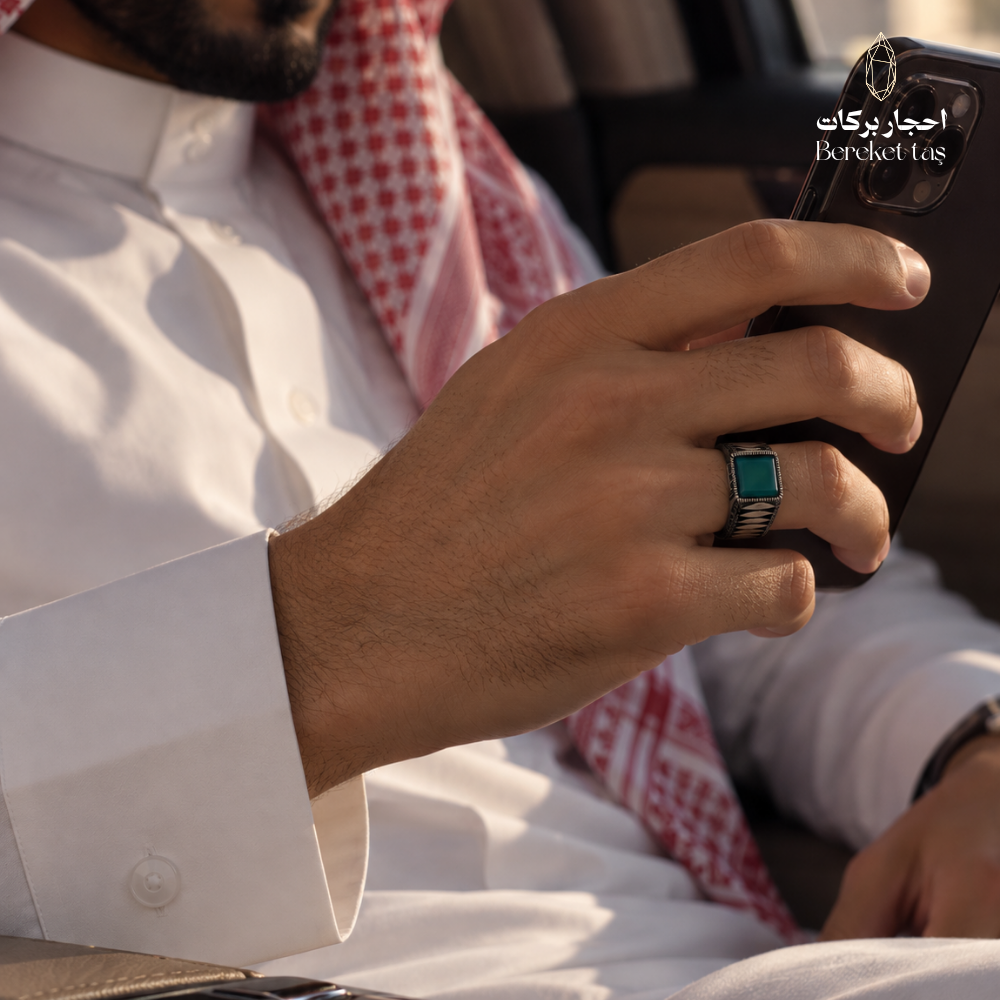 Man wearing a natural Green Agate ring in 925 Sterling Silver while seated in a car, highlighting the gemstone and detailed silver setting