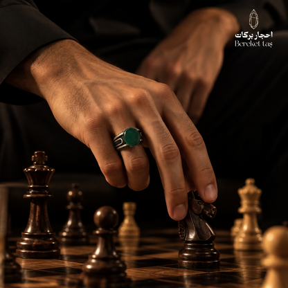 Man wearing a natural Green Agate ring in 925 Sterling Silver while playing chess, showcasing the green gemstone and detailed silver setting.