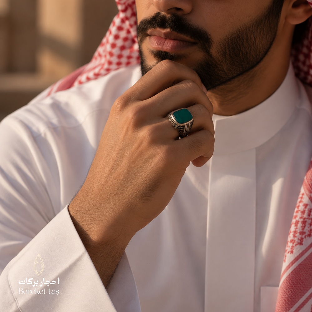 Man wearing a natural green agate ring in 925 sterling silver with an ornate setting, styled with traditional Gulf attire