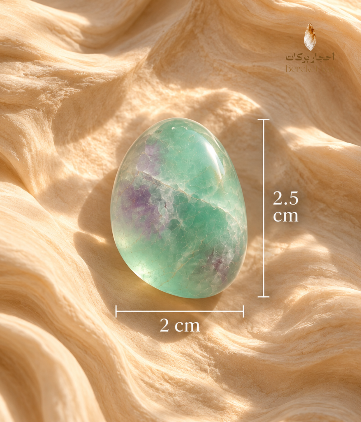Polished green fluorite stone with purple inclusions showing its 2.5 cm length and 2 cm width