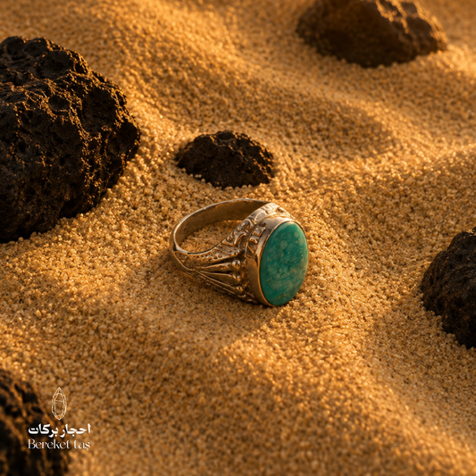 Iranian Nishapur turquoise ring in 925 sterling silver displayed on sand