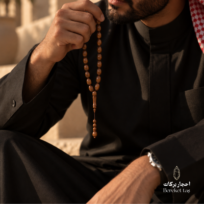 Natural Kuka Wood Prayer Beads held in hand, showcasing polished brown beads and classic design