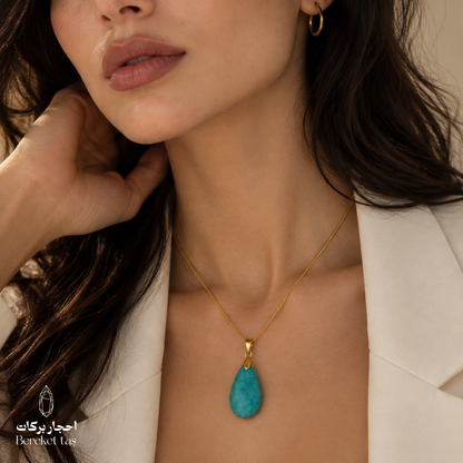 Natural Amazonite pendant necklace with a gold-plated chain worn with an elegant white outfit