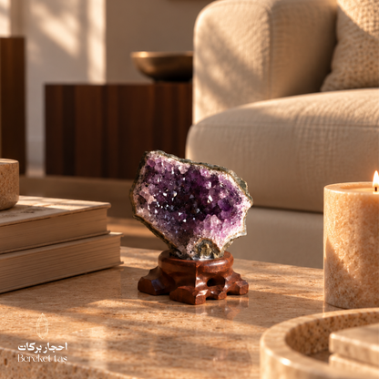 Natural Brazilian Amethyst crystal with purple formations displayed on a wooden stand in an elegant interior setting