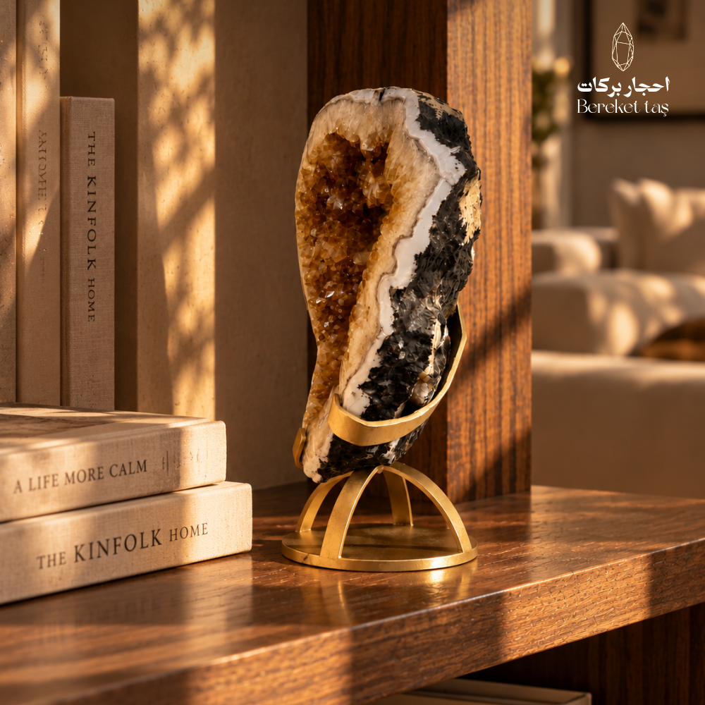 Natural Citrine geode with golden crystal formations displayed on a metal stand in a warm interior setting