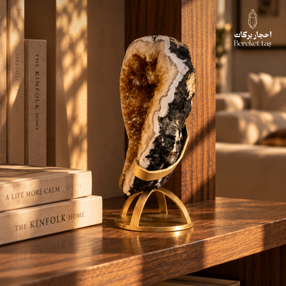 Natural Citrine geode with golden crystal formations displayed on a metal stand in a warm interior setting