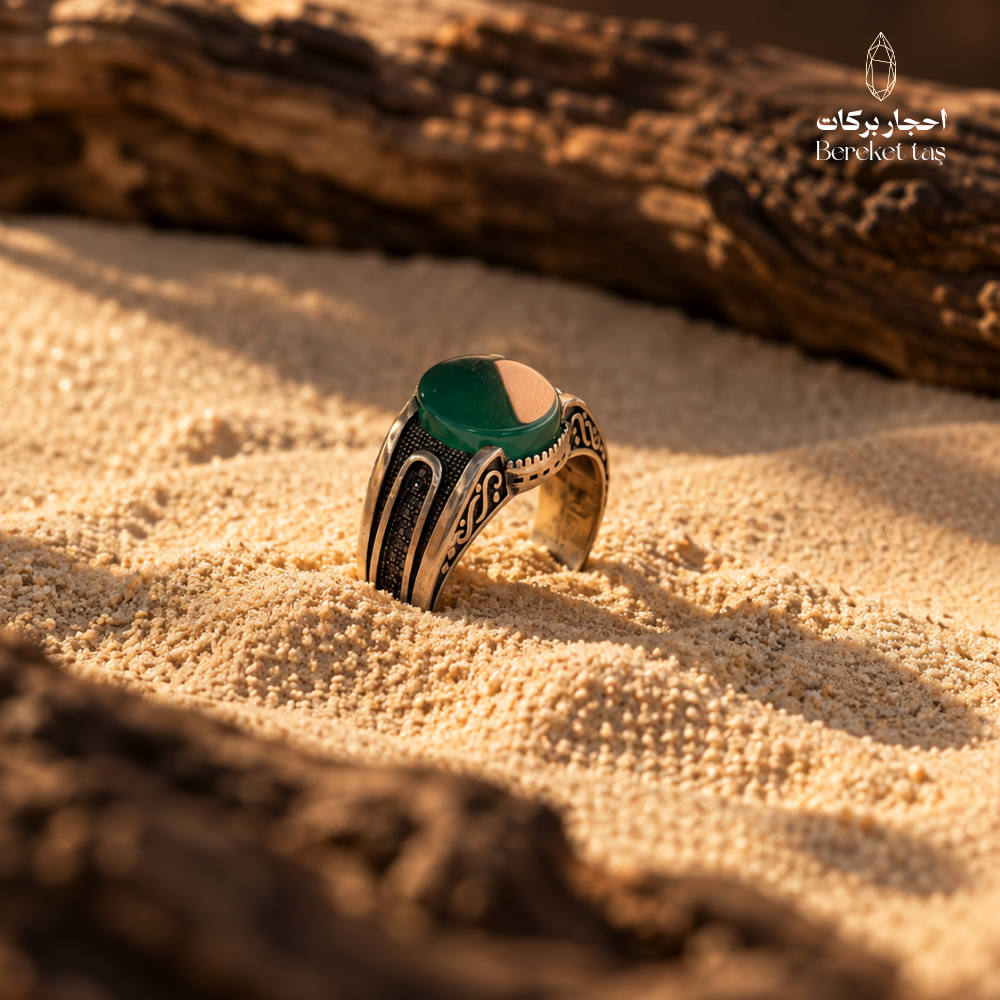 Natural Green Agate men's ring in 925 Sterling Silver displayed on warm desert sand, highlighting the green gemstone and ornate silver detailing.