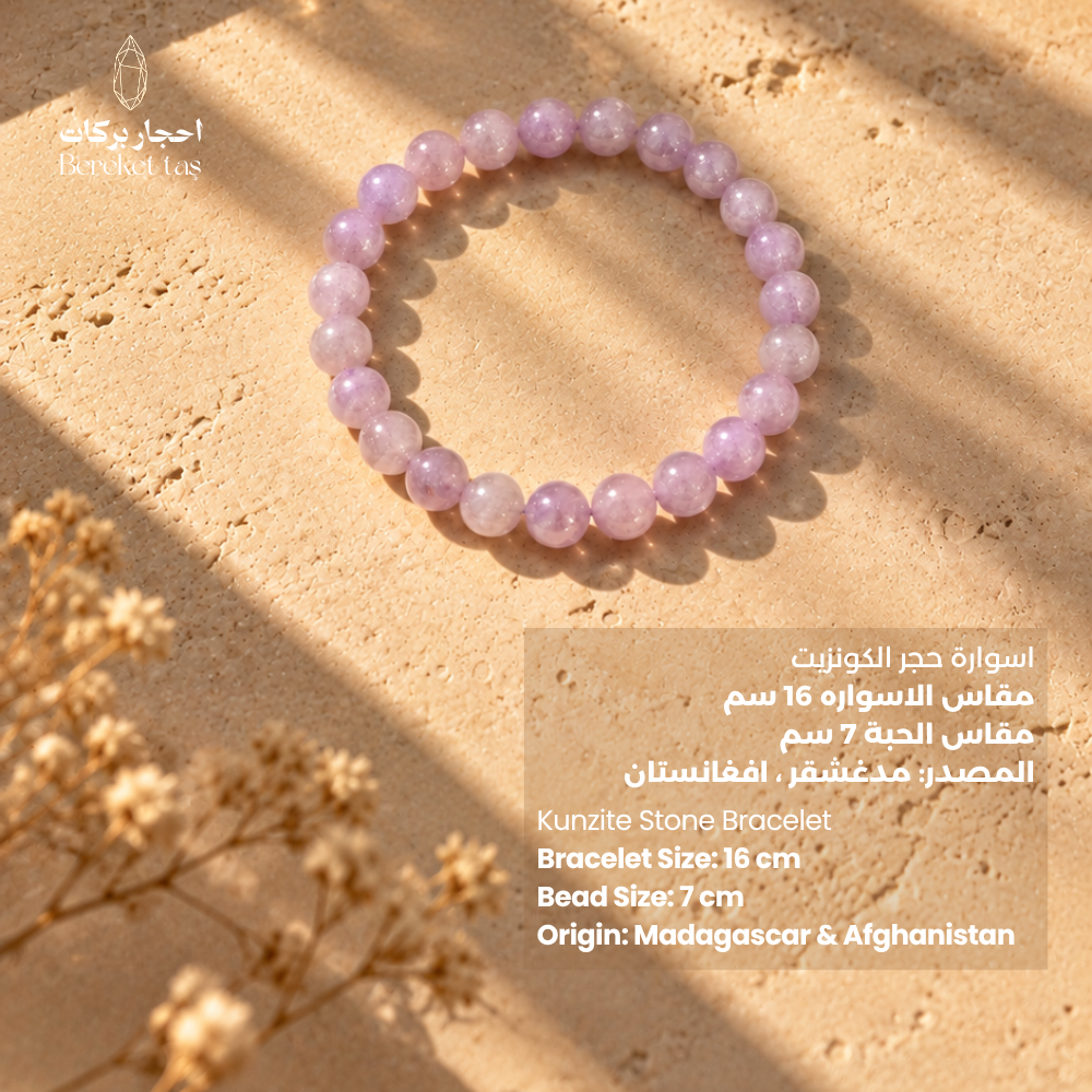 Natural Kunzite bracelet with 7 mm pink and purple gemstone beads on a warm stone surface