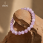 Natural Kunzite stone bracelet with soft pink and purple beads displayed on natural stone