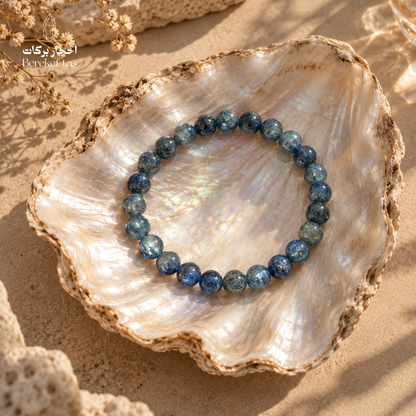 Natural Kyanite bracelet with blue gemstone beads displayed on a pearl shell