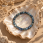 Natural Kyanite bracelet with blue gemstone beads displayed on a pearl shell