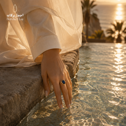 Natural Lapis Lazuli ring with deep blue gemstone worn by the water in warm sunlight