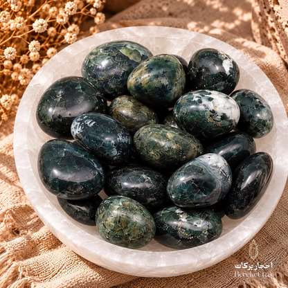 Collection of natural polished Moss Agate stones with dark green and white patterns displayed in a decorative stone bowl