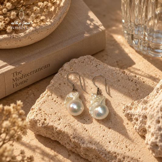 Natural Pearl drop earrings with 925 sterling silver hooks displayed on a textured stone surface