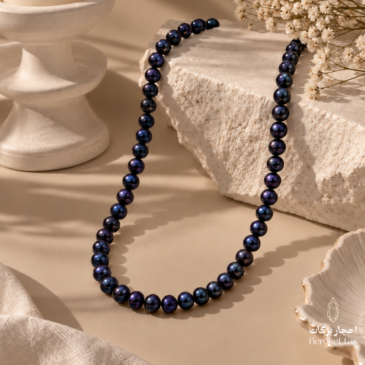 Natural Pearl beaded necklace with deep navy and black tones displayed on an elegant neutral surface