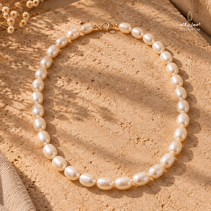 Natural Pearl handmade necklace arranged in a full-length display on a warm stone surface, showing its elegant pearl arrangement and clasp