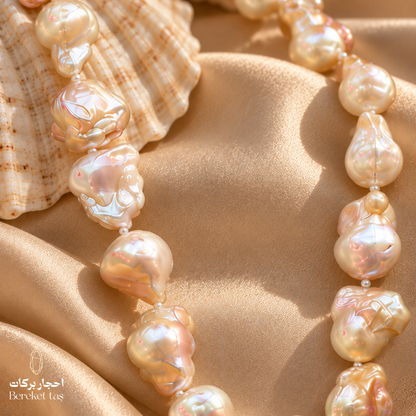 Natural Pearl necklace featuring luminous irregular beads arranged on soft satin fabric beside a seashell