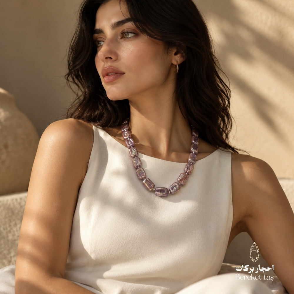 Handmade natural Pearl necklace in soft pink and mauve tones worn with an elegant white dress