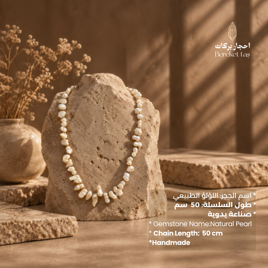 Natural white Pearl necklace displayed on a stone with a warm elegant setting