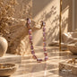 Handmade natural Pearl necklace in pink and light mauve tones displayed on a warm stone surface