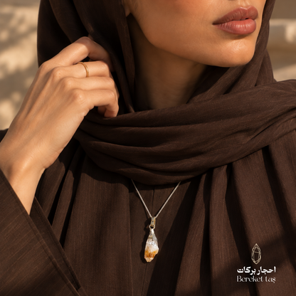 Natural raw Citrine pendant necklace with a silver chain styled with an elegant dark brown outfit