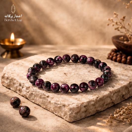 Natural Ruby Zoisite stone bracelet with deep purple gemstone beads displayed on a natural stone surface by Bereket Taş
