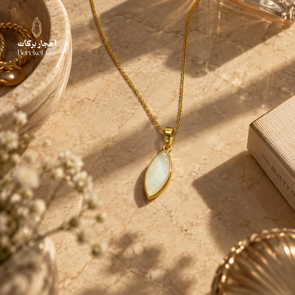 Natural shell stone pendant necklace with a gold-plated chain displayed on a warm stone surface