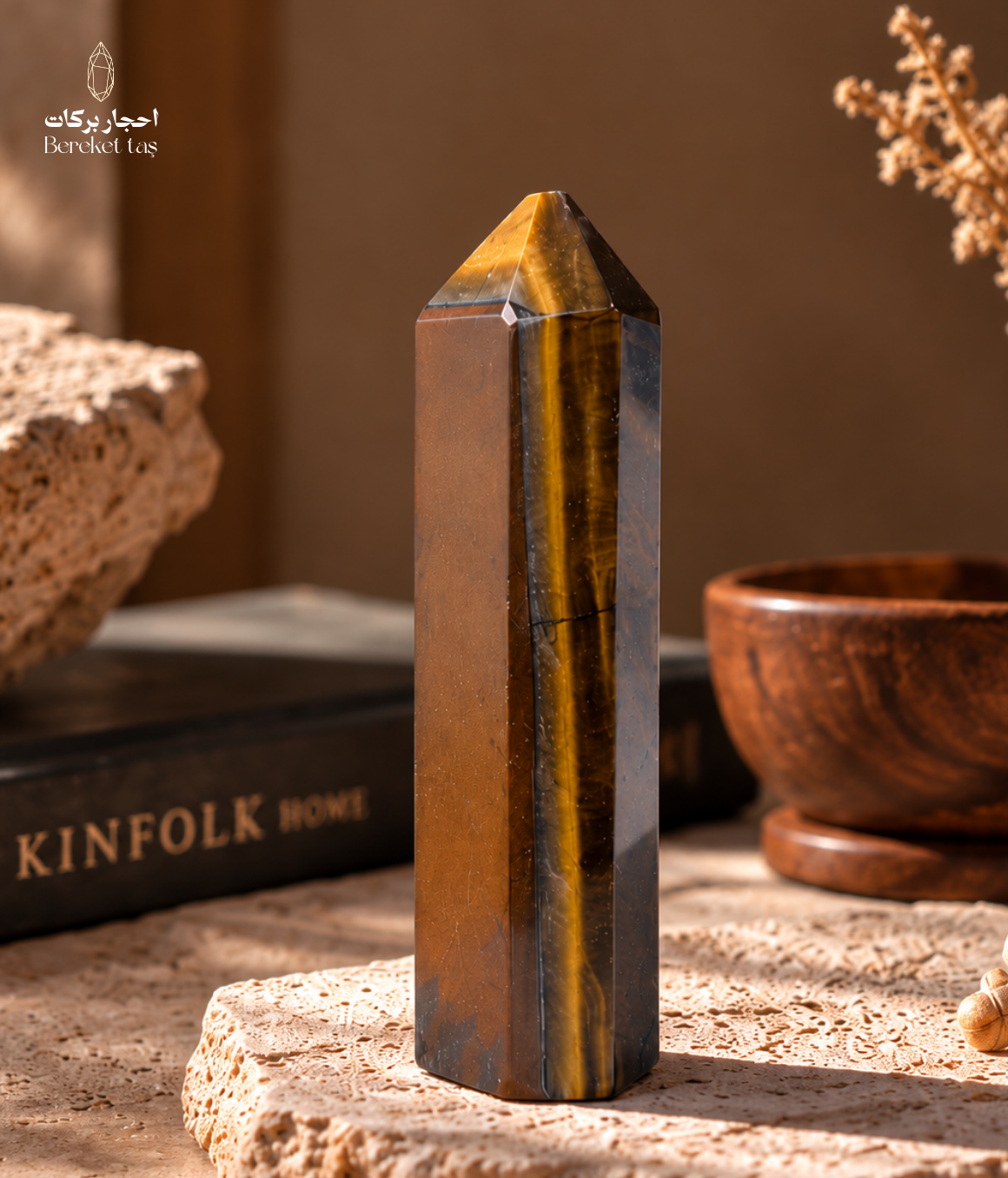Natural South African Tiger’s Eye stone with golden chatoyancy displayed upright on a travertine surface