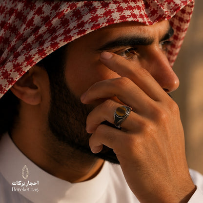 Natural Tiger Eye ring with honey brown stone and 925 silver, worn by a man in a white thobe
