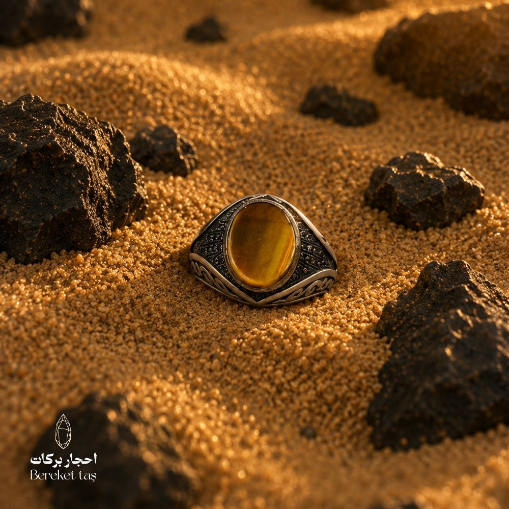 Natural Tiger Eye ring with honey brown stone and 925 silver, photographed on sand with natural rocks