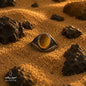 Natural Tiger Eye ring with honey brown stone and 925 silver, photographed on sand with natural rocks