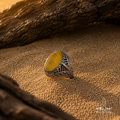 Natural Tiger Eye ring with honey brown stone and 925 silver, photographed on a natural textured surface