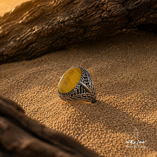 Natural Tiger Eye ring with honey brown stone and 925 silver, photographed on a natural textured surface